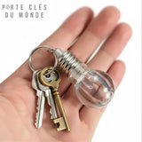 Porte clés ampoule lumineuse tenu dans la main, format compact et pratique pour le quotidien