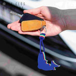 Porte clés flottant bleu en forme de requin, tenu en main