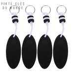 Lot de 4 porte-clés flottants noirs alignés sur fond blanc