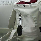 Porte-clé flottant noir accroché à un sac de sport blanc