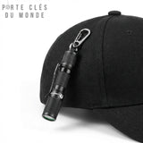 Porte clé lampe torche avec mousqueton posé sur une casquette, usage lampe frontale pratique