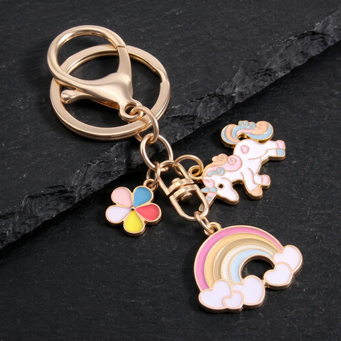 Porte-clé licorne arc-en-ciel doré avec pendentifs colorés sur fond noir