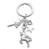 Porte-clé licorne magique avec licorne cabrée, fée ailée, étoile et cœur ajouré sur fond blanc