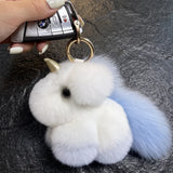 Porte clé licorne en peluche blanche et bleu pastel avec corne dorée et longue queue douce