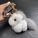 Porte clé licorne en peluche blanche et grise avec longue queue douce, corne dorée et anneau métallique