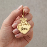 Porte-clé licorne personnalisé doré présenté dans une main, avec licorne souriante et cœur portant l’inscription « Name »