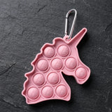 porte-clé licorne pop it rose avec mousqueton métalique sur fond sombre