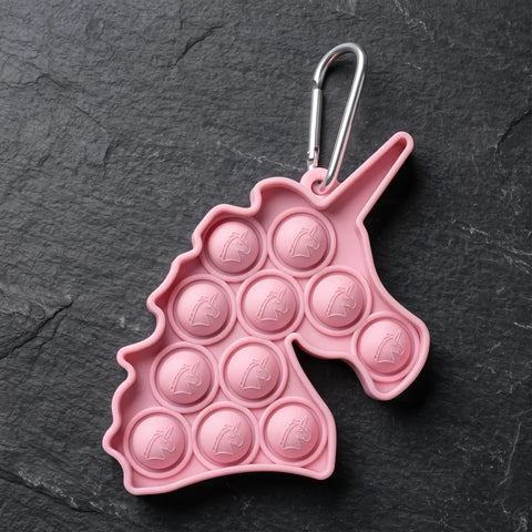 porte-clé licorne pop it rose avec mousqueton métalique sur fond sombre