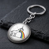 Porte-clé licorne vomissant un arc-en-ciel sur fond noir