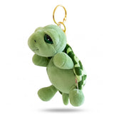 Porte clé tortue peluche avec carapace rayée et anneau doré sur fond blanc