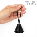 Porte clé pompon cuir noir tenu en main, accessoire de clés chic et luxueux pour sac ou trousseau