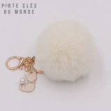 porte-clés pompon fourrure blanc crème douce et très poilu et breloque chat avec anneau et mousqueton doré sur fond blanc 
