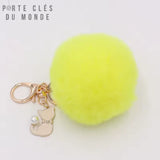 porte clé pompon fourrure jaune fluo, avec chat et mousqueton doré sur fond blanc 