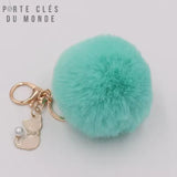 pompon porte clé fourrure turquoise sur fond blanc avec breloque chat et mousqueton doré
