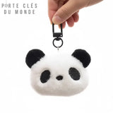 Porte clé pompon tête de panda tenu en main, détail du visage et de la fourrure