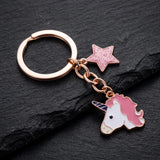 Porte-clé tête de licorne rose, tête blanche à crinière rose et corne bleue avec étoile pailletée sur fond sombre