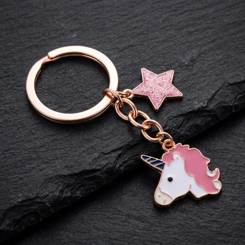Porte-clé tête de licorne rose, tête blanche à crinière rose et corne bleue avec étoile pailletée sur fond sombre