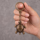 Porte clé tortue antique à finition bronze vieilli tenu en main