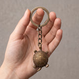 Porte clé tortue antique en métal bronze vieilli tenu en main