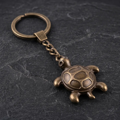 Porte clé tortue antique avec carapace en relief et finition bronze vieilli sur fond sombre