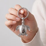 Porte clé tortue argent tenu en main