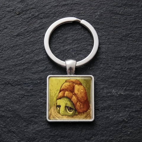 Porte clé tortue cabochon avec illustration de tortue sur fond noir