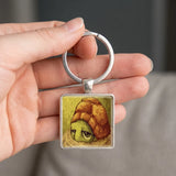 Porte clé tortue cabochon carré tenu dans la main
