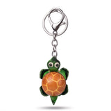 Porte clé tortue cuir coloris orange tenu en main