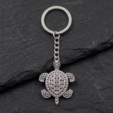 Porte clé tortue métal argenté avec motifs gravés sur fond ardoise