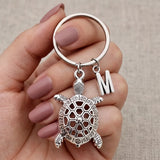 Porte clé tortue personnalisé avec initiale tenu en main