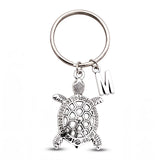 Porte clé tortue personnalisé argenté avec pendentif initiale sur fond blanc