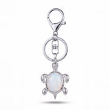 Porte clé tortue pierre opale blanche aux reflets nacrés avec monture argenté