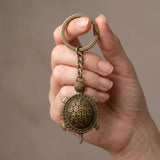 Porte clé tortue rétro en métal bronze vieilli tenu en main