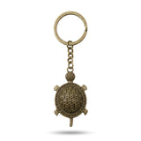 Porte clé tortue rétro en métal bronze vieilli sur fond blanc