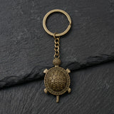 Porte clé tortue rétro en métal bronze vieilli sur fond ardoise