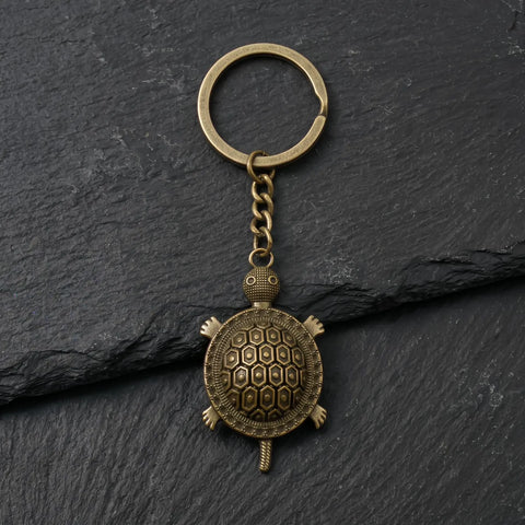 Porte clé tortue rétro en métal bronze vieilli sur fond ardoise
