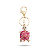 Porte clé tortue zircon rose et doré à strass sur fond blanc