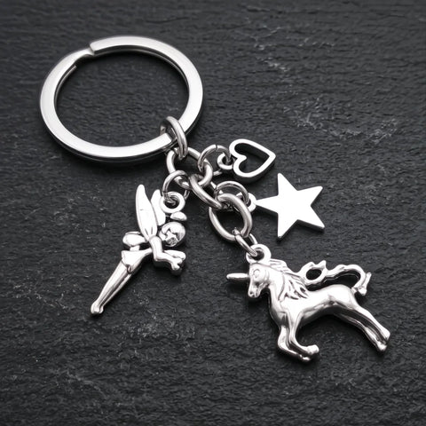 Porte-clef licorne magique avec breloques fée, étoile et cœur argentées sur fond sombre