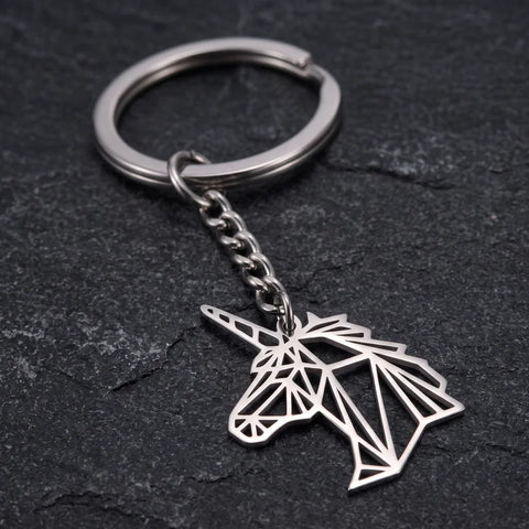 Porte-clef licorne origami, tête argentée aux découpes géométriques sur fond sombre