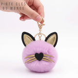Porte clé chat pompon rose pastel tenu en main, accessoire félin doux et mignon pour clés ou sac avec oreille et moustache doré