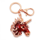 Porte-clés licorne rouge avec strass et finition dorée sur fond blanc